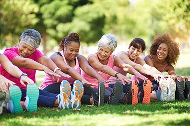 Group of ladies touching their toes while exercising
