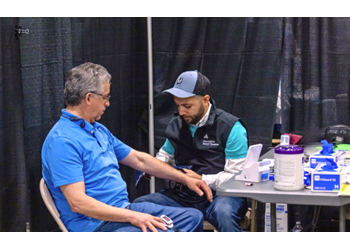 Ascension associate assisting an attendee with medical services.